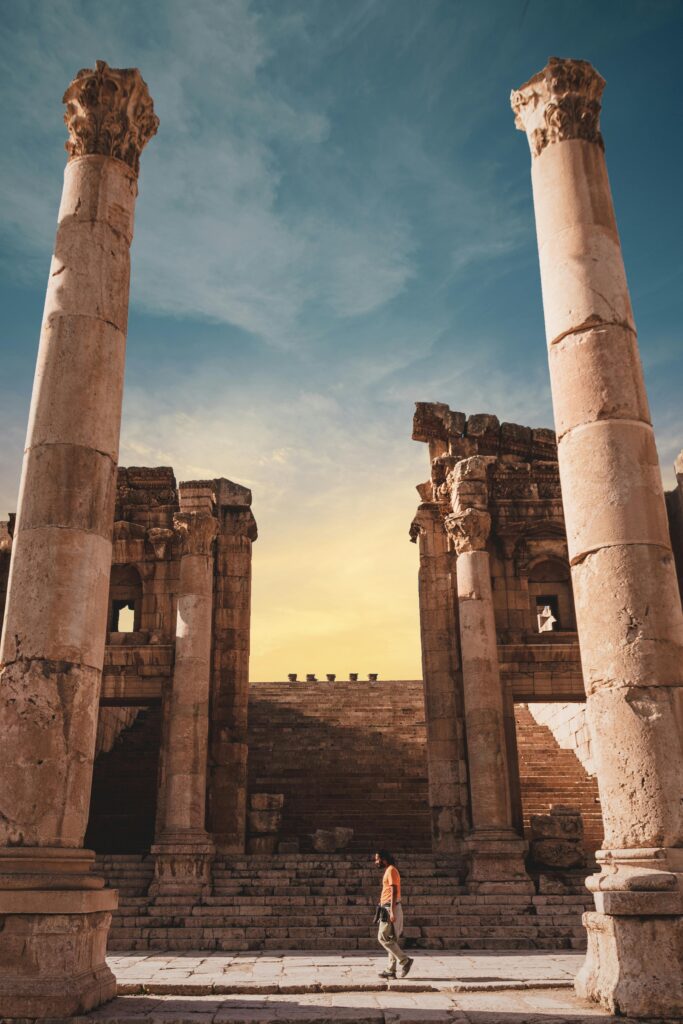 Explore the ancient Roman ruins in Jerash, Jordan, set against a vibrant sunset sky.